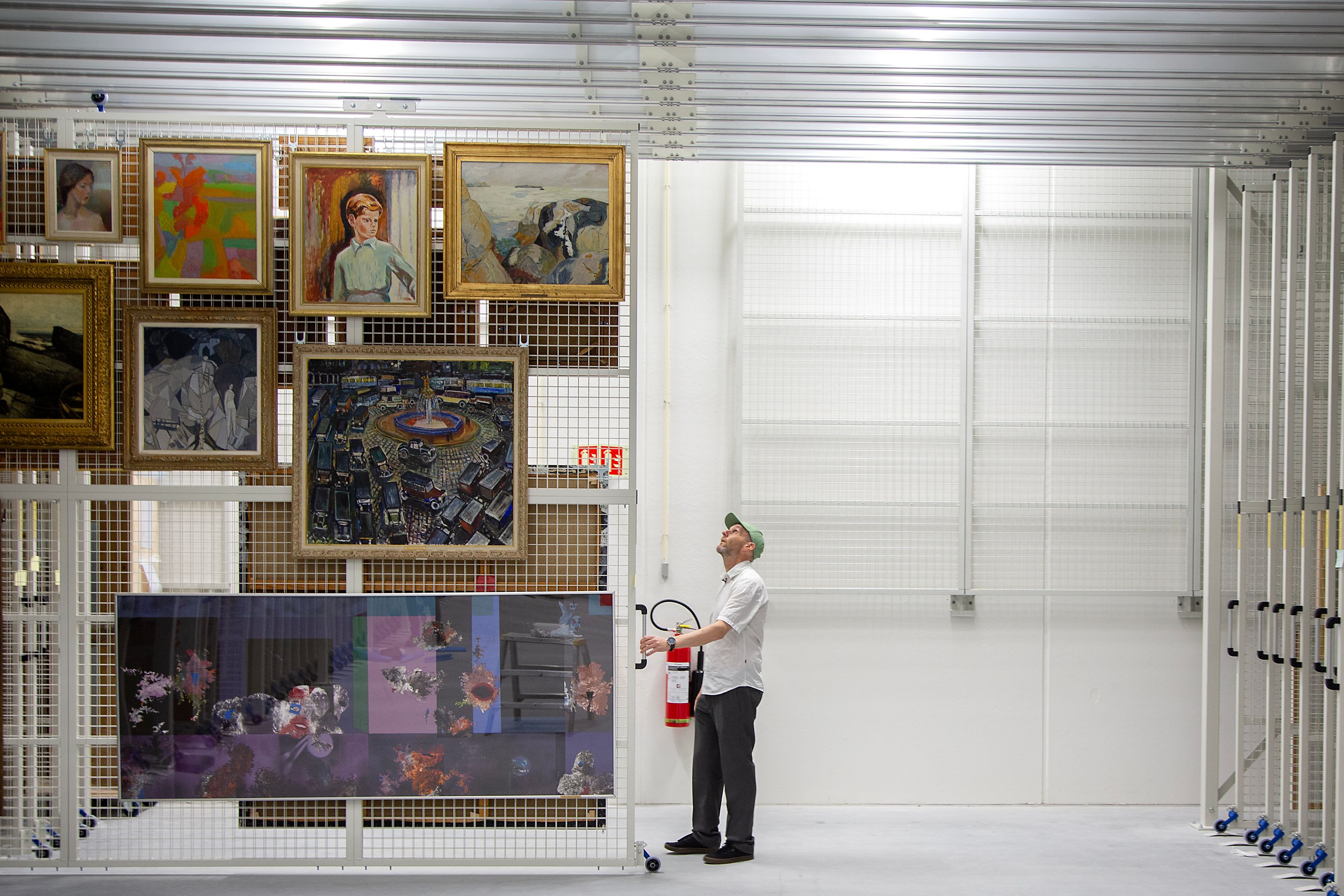 Curator looks at art work in the art storage