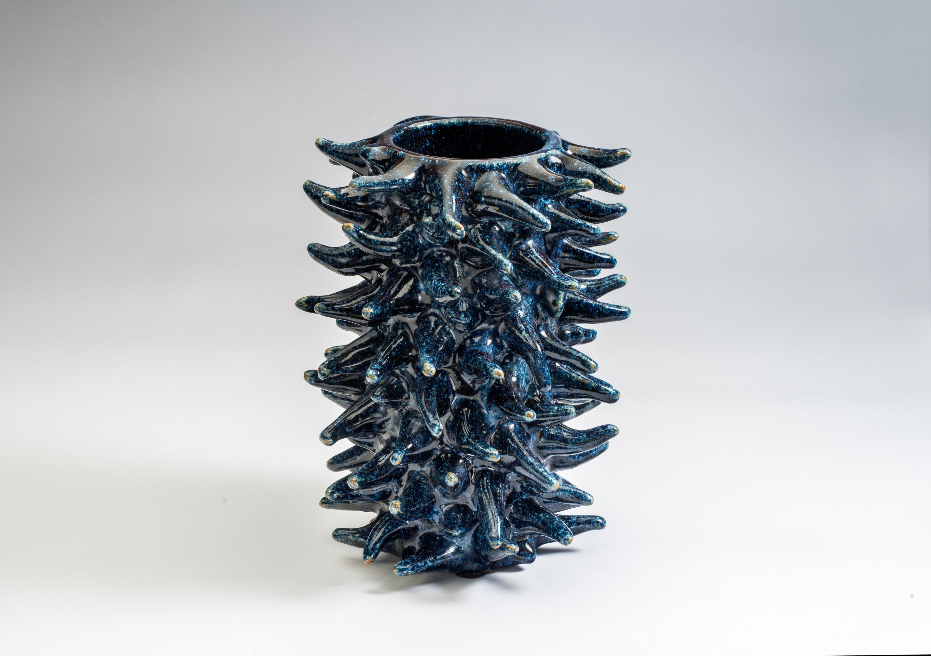 Blå vase i keramikk med spisse tagger som står ut til siden